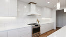 Forno Aria 48-Inch 1,200 CFM Wall Mount Range Hood in White with Brass Handle shown in a styled kitchen