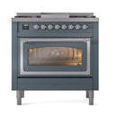 Blue grey dual-fuel gas range front view, lit oven window and control knobs