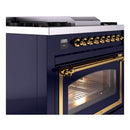 Midnight blue range control panel with brass knobs and oven door with glass window