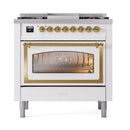 White dual-fuel gas range with brass-trim oven door glass and six black burner grates