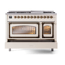 Freestanding range close front view with lit oven windows and bronze control knobs