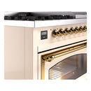 Freestanding dual fuel range control panel with brass knobs and brass oven handle.