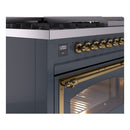 Close-up of brass control knobs and handle on blue grey freestanding dual fuel range.