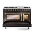 Freestanding dual fuel range front with ovens open and illuminated, glossy black and brass trim