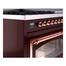 Burgundy dual fuel range control panel with copper knobs and display, beside lit oven door