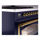 Midnight blue freestanding gas range control panel with brass knobs and oven handle