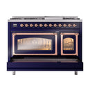 Freestanding midnight blue range with copper trim; oven doors open with glowing interiors.