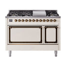 Antique white dual-fuel range with bronze control knobs, grates, and double solid-door ovens