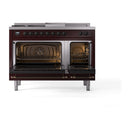 Burgundy dual fuel range with two ovens open, bronze trim, and lit oven interiors