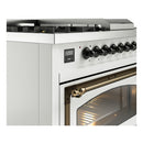 Nostalgie II dual fuel range, close view of bronze oven handle and control knobs on white.