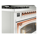 Dual-fuel range close-up with copper control knobs and brushed metal oven handle