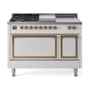 White ILVE dual fuel range front with glass doors, brass trim, burners and griddle