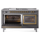 Matte graphite dual-fuel range with one oven open and brass-trim glass door, interior racks visible