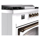 White dual-fuel range control area with digital display and bronze burner knobs