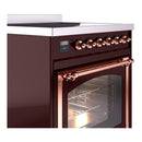 Burgundy induction range corner view with copper knobs and oven door open.