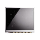 Induction cooktop with black glass surface and silver frame, brass trim at base.