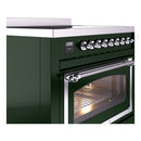 Emerald green induction range close-up: chrome control knobs, door handle and oven window