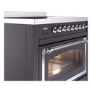 Matte graphite induction range close-up: chrome knobs and oven door with glass
