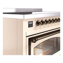 Antique white induction range with bronze control knobs and oven window, close-up