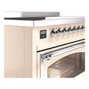 Induction range control panel with chrome knobs above a glass oven door.