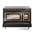 Induction range front view with lit oven interiors through glass doors and brass trim