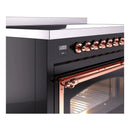 Induction range control section with copper knobs and copper-trimmed oven handle