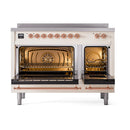 Antique white induction range with copper trim, top knobs, and two open oven doors