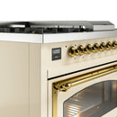 Antique white dual fuel range close-up of brass oven handle and gold control knobs
