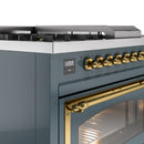 Blue grey range front with brass oven handle and burner knobs, close-up control panel