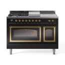 Black range with brass knobs and French top; triple glass oven doors with brass accents.
