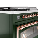 Close-up of emerald green range front with copper control knobs and oven door edge