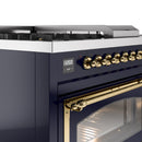 Midnight blue oven control panel with brass knobs and a brass-trimmed oven handle