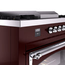 Burgundy ILVE range control panel with digital display and polished chrome control knobs