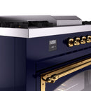 Midnight blue ILVE range control panel with brass knobs and digital clock display