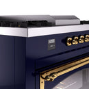 Midnight blue dual fuel range control panel with brass knobs and digital display