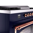 Midnight blue dual fuel range control panel with copper knobs and clock display