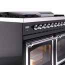 Dual fuel range control panel with chrome knobs and lit oven window detail