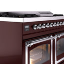 Burgundy dual fuel range close-up of chrome control knobs and open oven door
