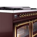 Close-up of burgundy range control panel with brass knobs and open glass oven door