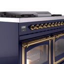 Midnight blue dual fuel range control panel and brass oven handle with lit oven door