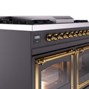 Close-up of brass control knobs and matte graphite range with oven door handle
