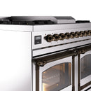 Stainless dual-fuel range control panel with bronze knobs, digital display, and oven handles