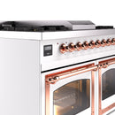 White dual fuel range control panel with copper knobs and oven handle detail