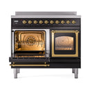 Glossy black induction range with brass trim, one oven door open and racks visible
