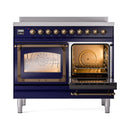 Midnight blue induction range with one open oven door, illuminated interior, bronze trim