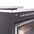 Matte graphite induction range control knobs with digital clock display and chrome handle.