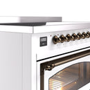 White induction range with bronze control knobs and open oven door with glass window
