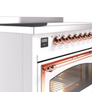 White induction range control panel with copper knobs and display and door handle
